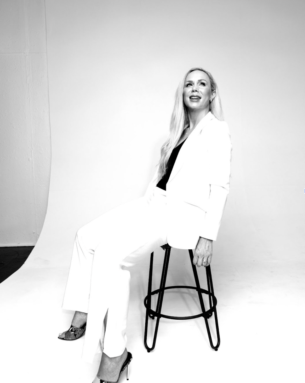 Black and white photo of Janna Johnson in a white suit, representing resilience, empowerment, and overcoming narcissistic abuse